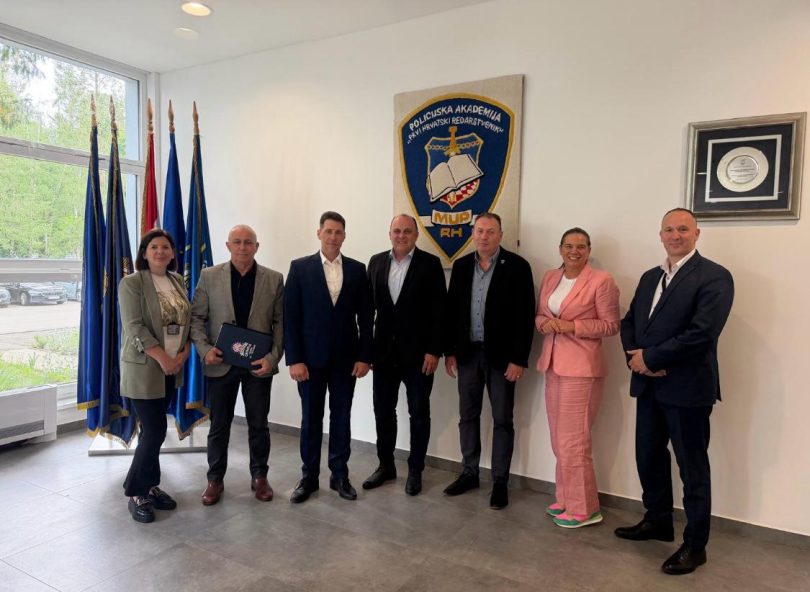 Grupa zvaničnika u službenim odijelima na sastanku suradnje MUP-a i Policijske akademije