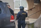 Policajac Federal upravnog podjetka u tamnoj uniformi prije zgrade tijekom operacije