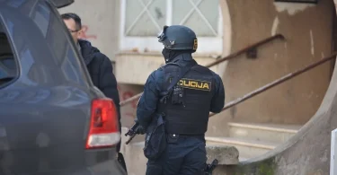 Policajac Federal upravnog podjetka u tamnoj uniformi prije zgrade tijekom operacije