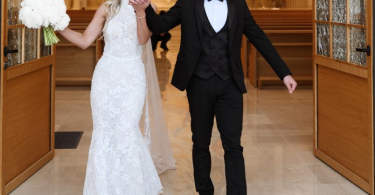 Mladoženja i mladenka u vjenčanoj odjeći izlaze iz crkve holding hands