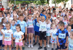 Grupa djece u sportskim dresovima na startnoj liniji trkačke utrke