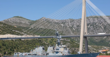 Američki vojna brod plovi ispod Elafitskog mosta u Dubrovniku uz jasno nebo