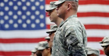 Američki vojnici u uniformi pred američkom zastavom