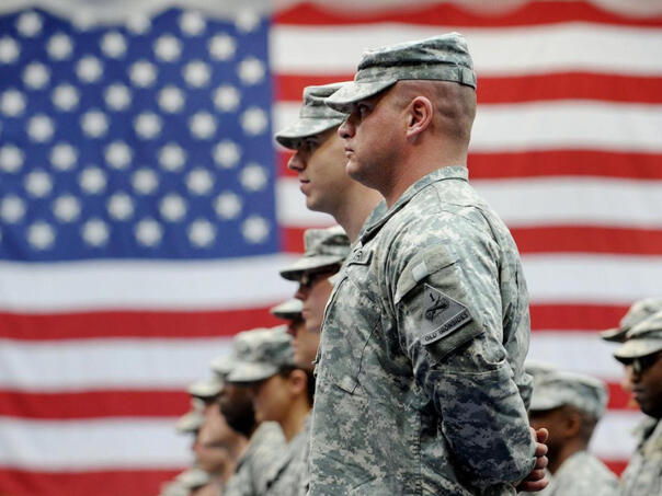Američki vojnici u uniformi pred američkom zastavom