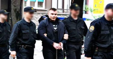 Policajci vode muškarca u civilu tijekom policijske akcije na gradskoj ulici
