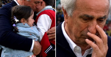 Stariji muškarac s bijelom kosom u emotivnom trenutku, drži dijete i ima ruku na licu