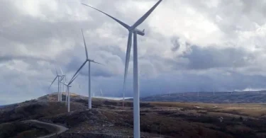 Tri vjetroturbine na planini s oblacima na nebu