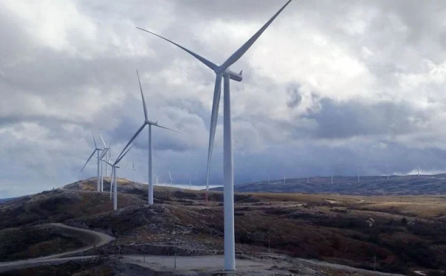 Tri vjetroturbine na planini s oblacima na nebu