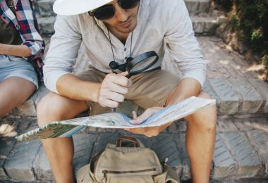 young traveler with map loupe